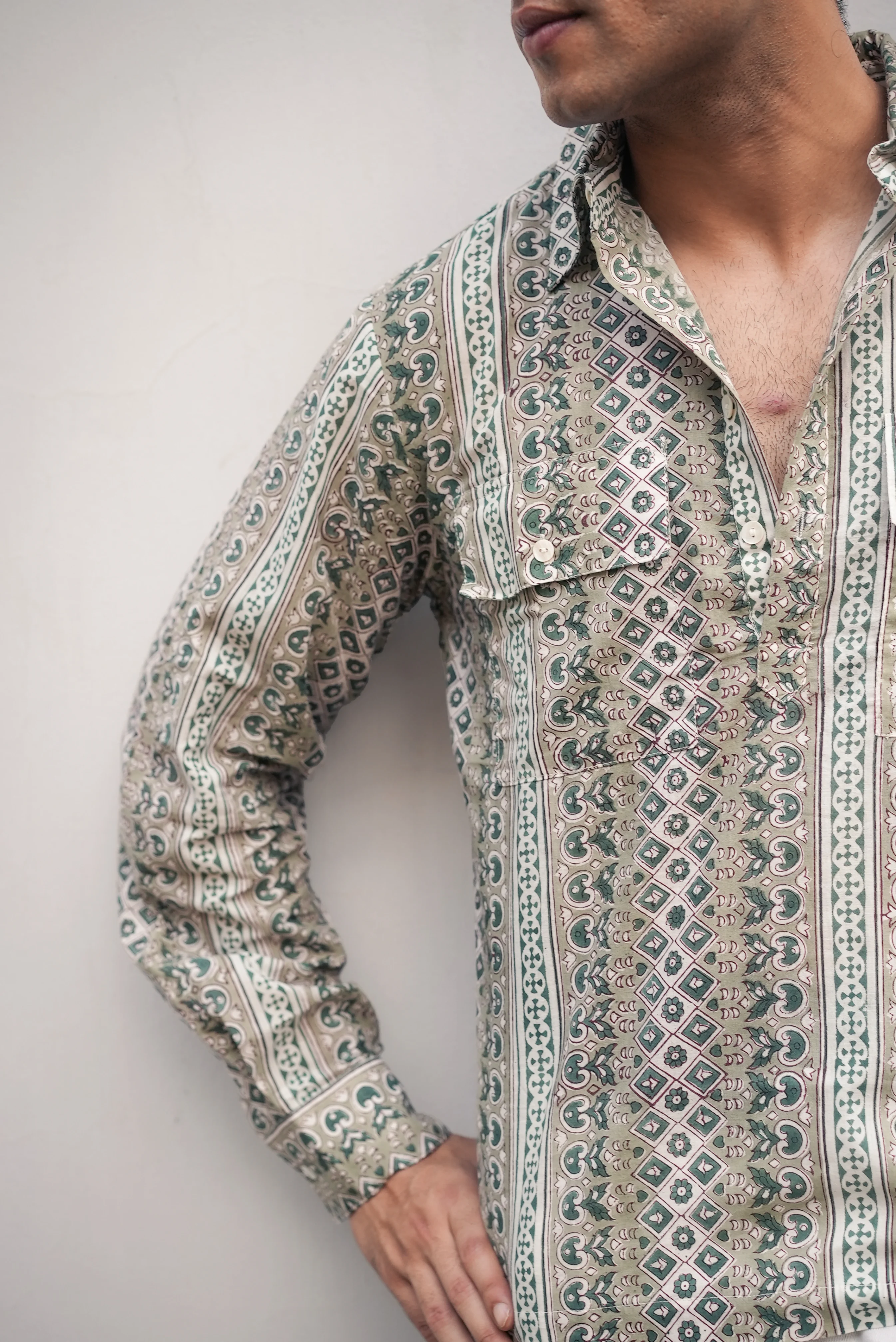 Person wearing a patterned Sattva and Sage shirt with a neutral background.