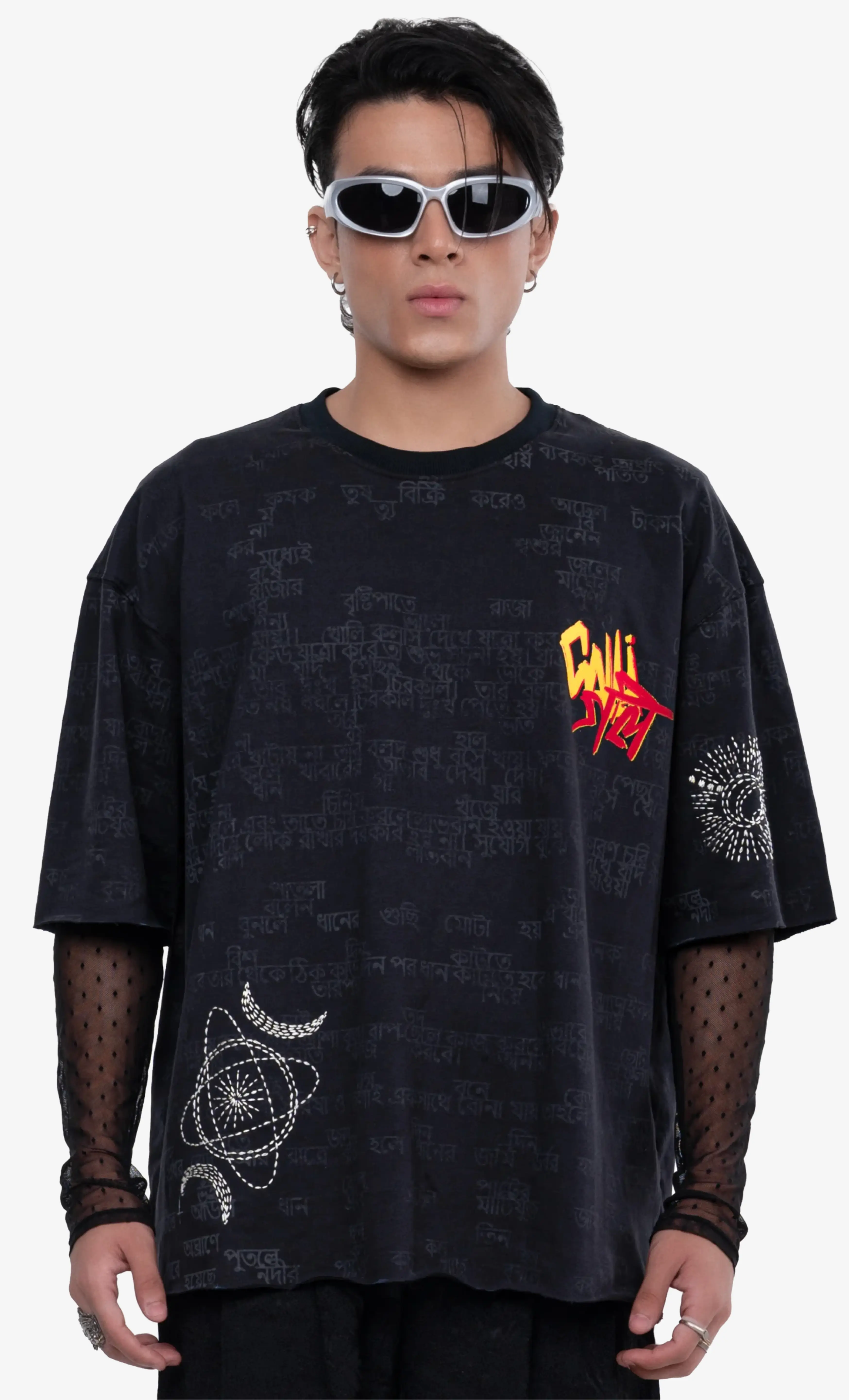 Model wearing a black oversized Sattva & Sage tee with red and white typography, photographed against a clean white background.