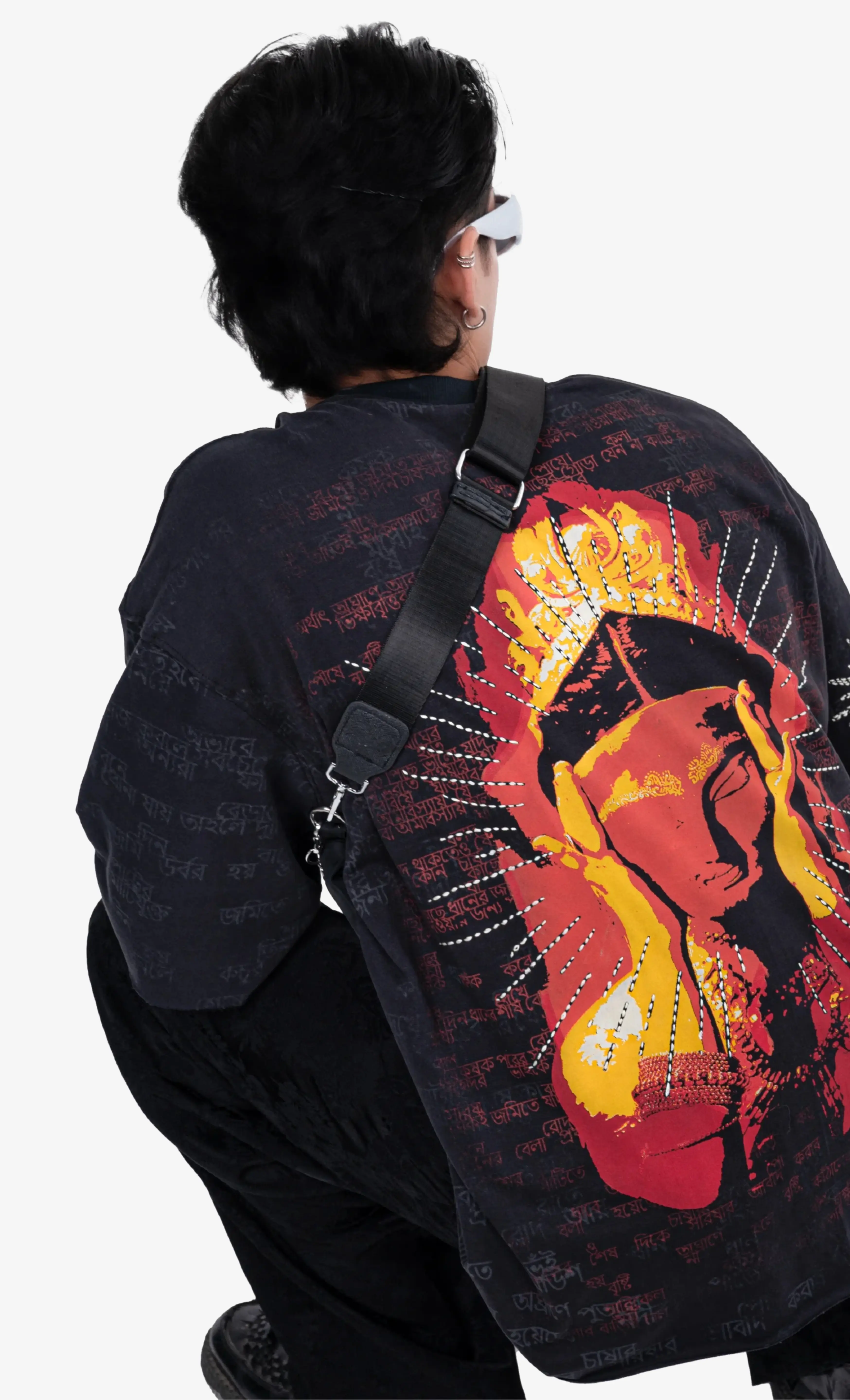 Person wearing a black shirt with a colorful graphic design of a face.