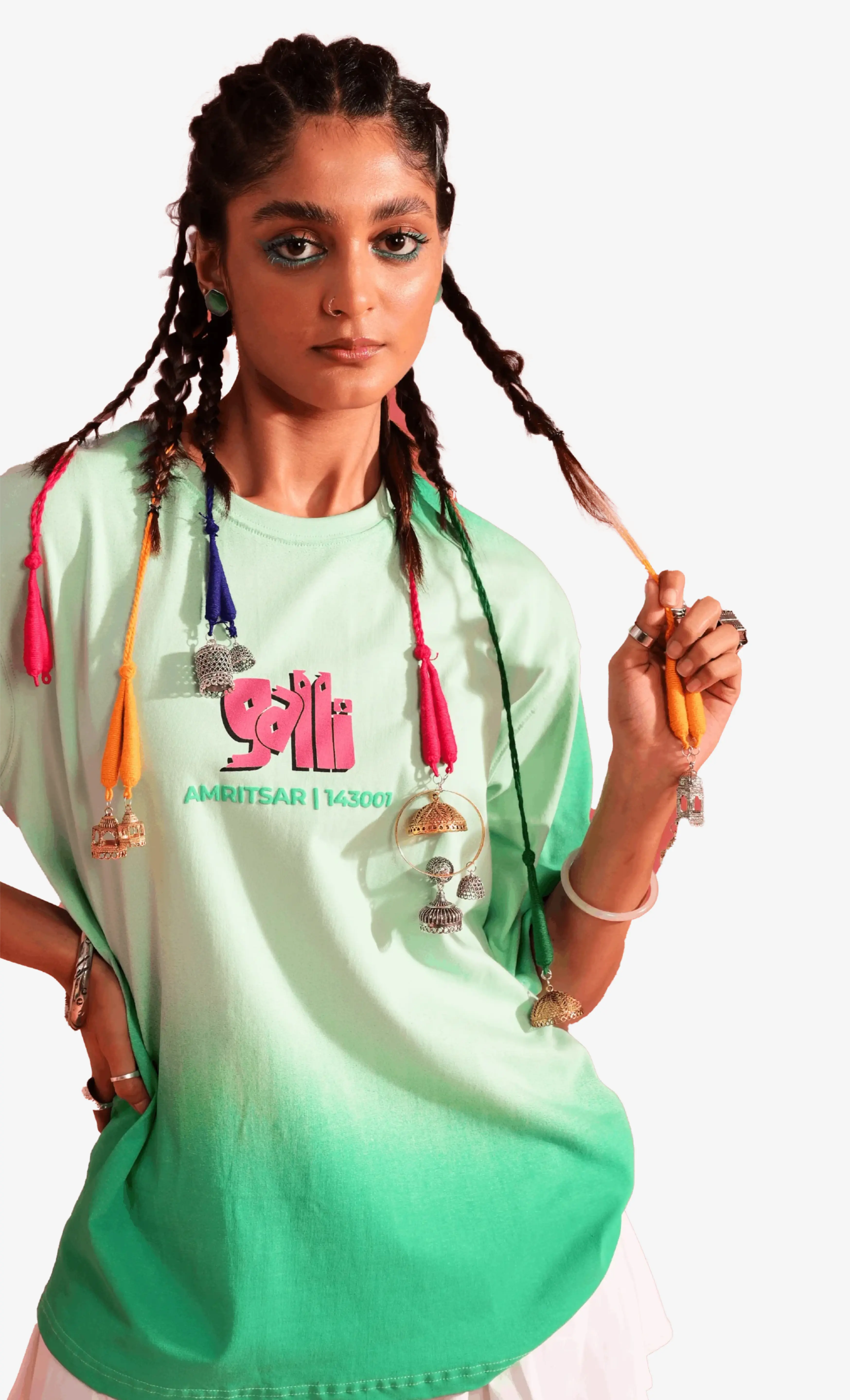 Person wearing a green and white gradient Sattva and Sage t-shirt with colorful accessories on a white background.