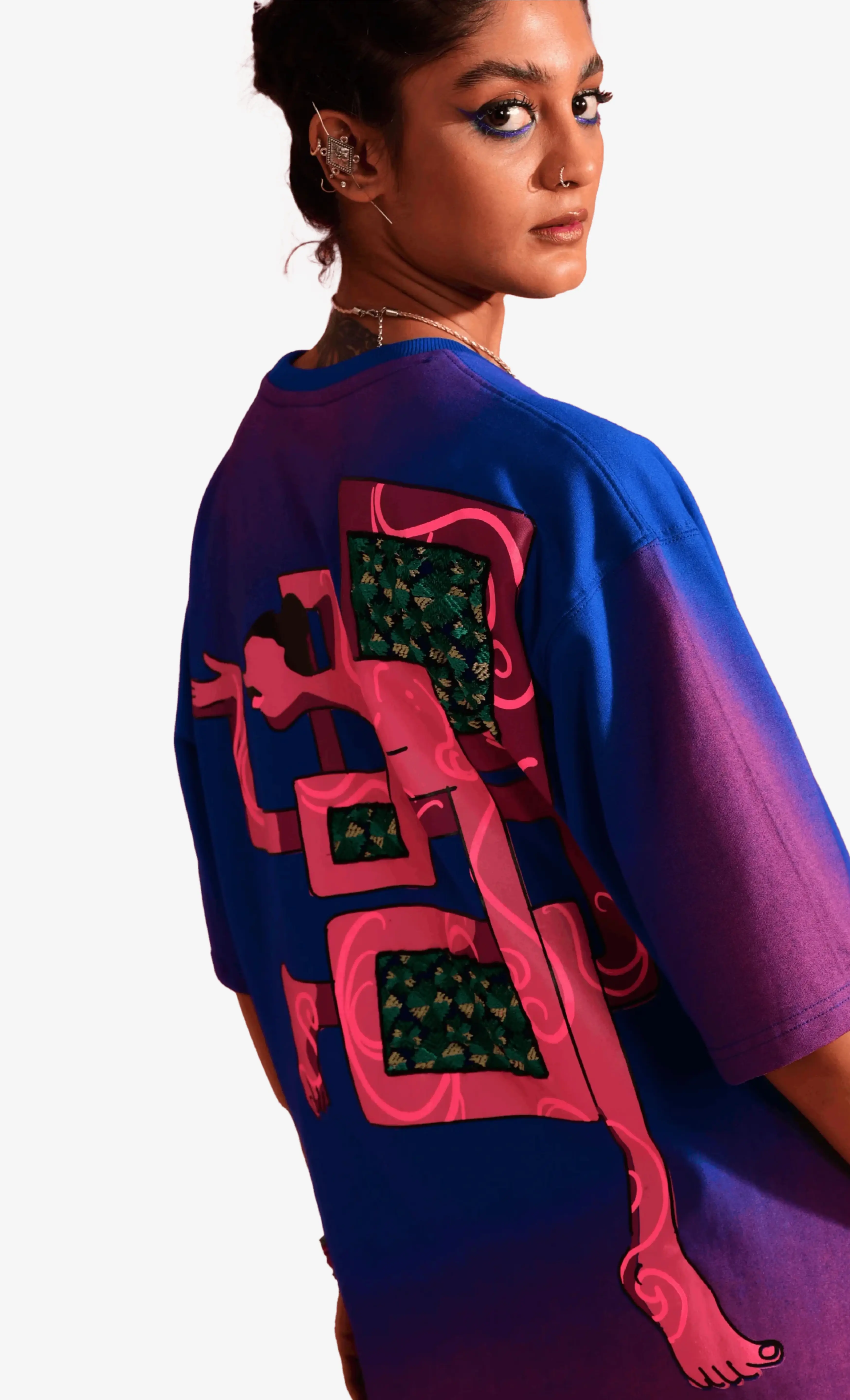 Person wearing a colorful, abstract-patterned Sattva and Sage t-shirt on a white background.