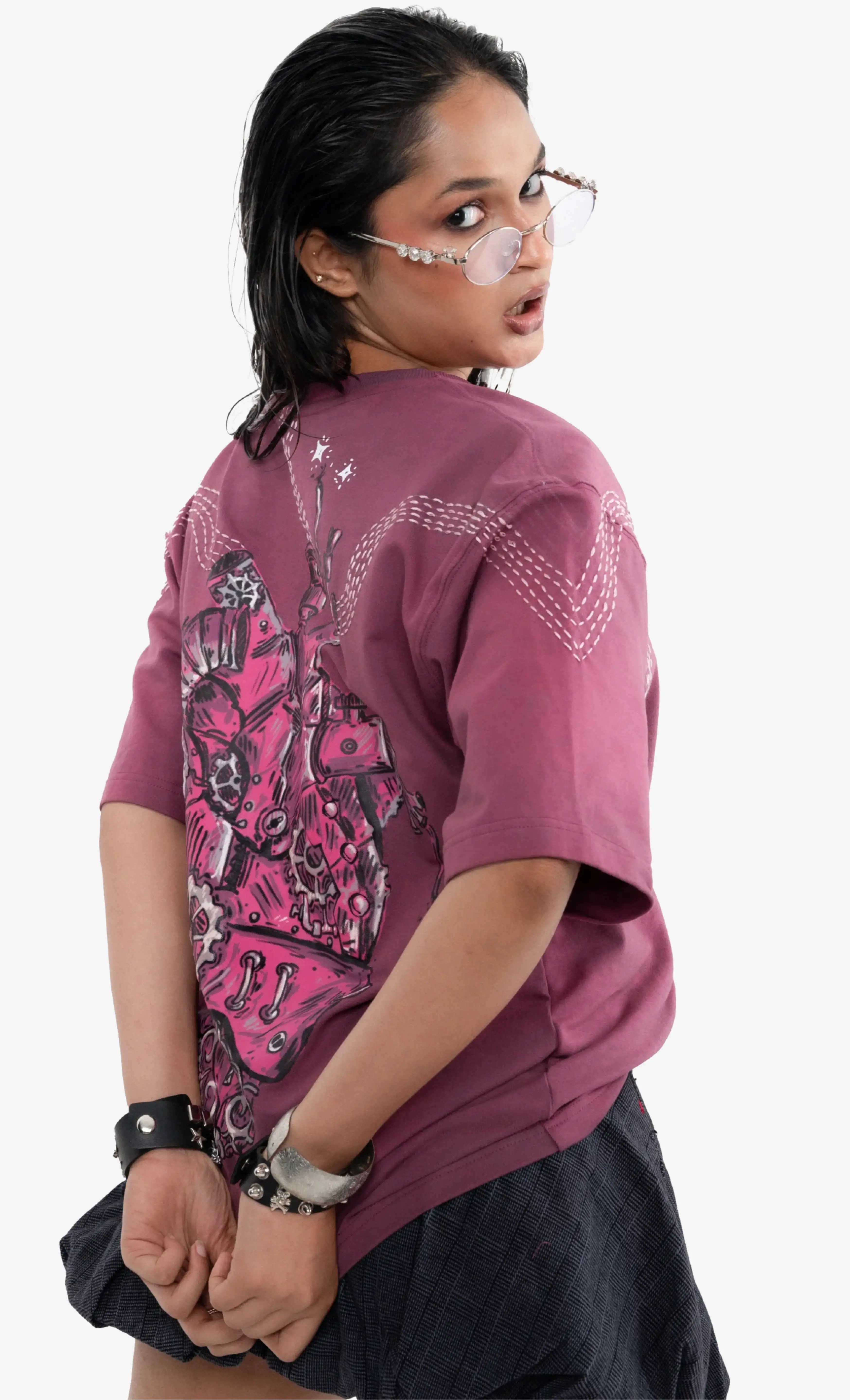 Person wearing a purple t-shirt with pink designs on a white background