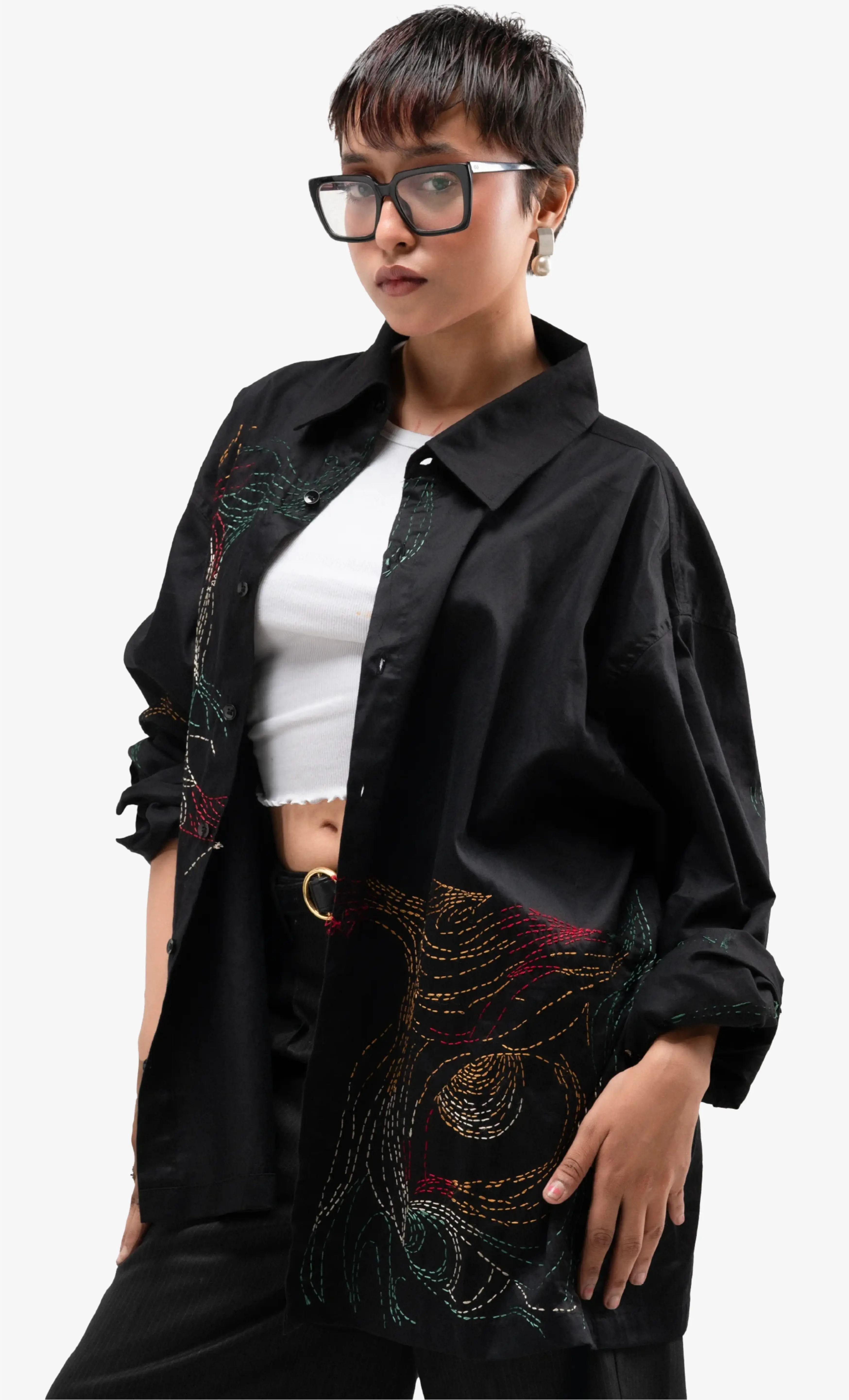 Model wearing a black embroidered Sattva & Sage jacket over a white top against a white background.