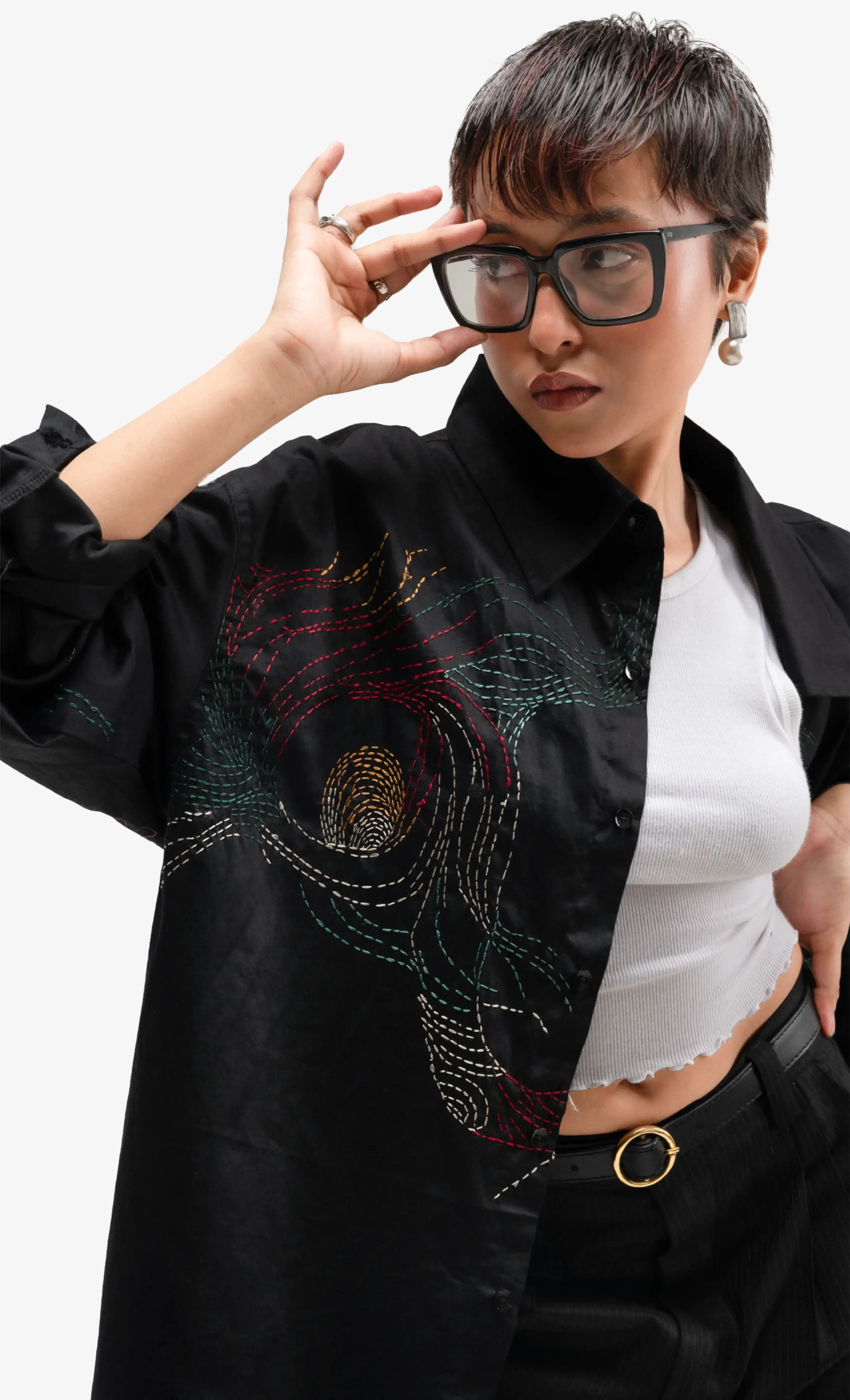 Model wearing a black embroidered Sattva & Sage jacket layered over a white top, photographed against a plain background.
