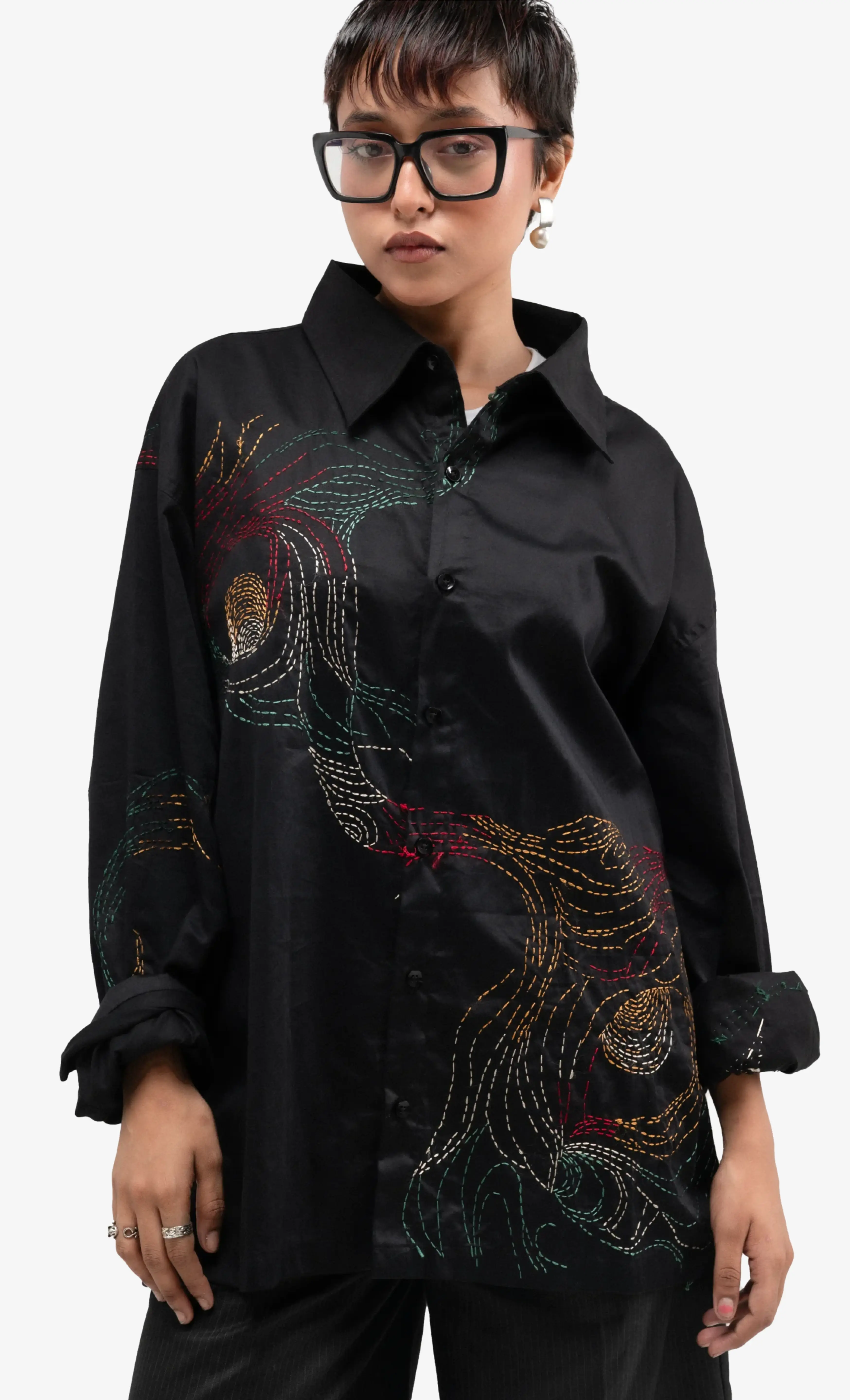 Model wearing a black embroidered Sattva & Sage shirt against a clean white background.