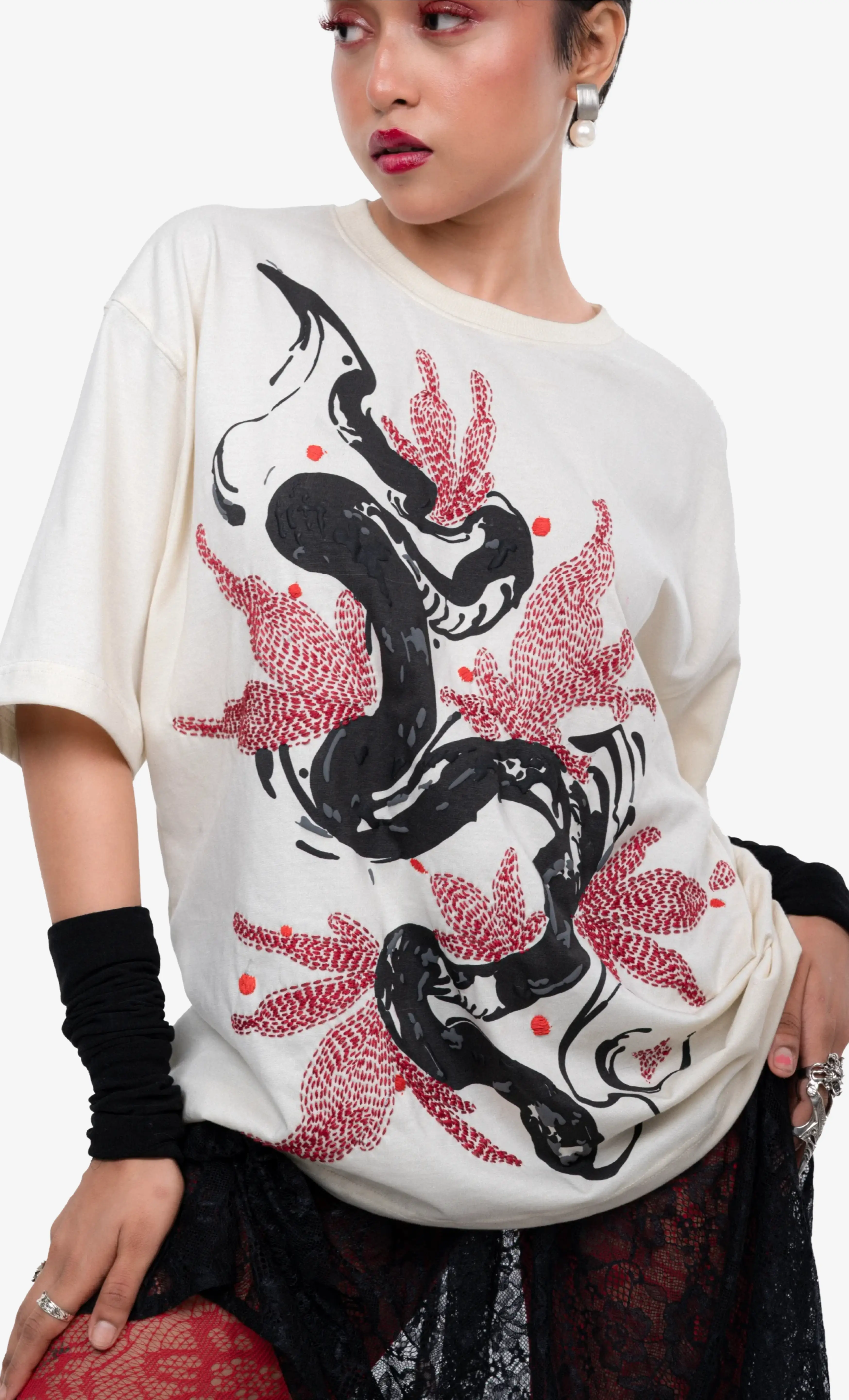 Person wearing a white t-shirt with black and red snake design on a plain background