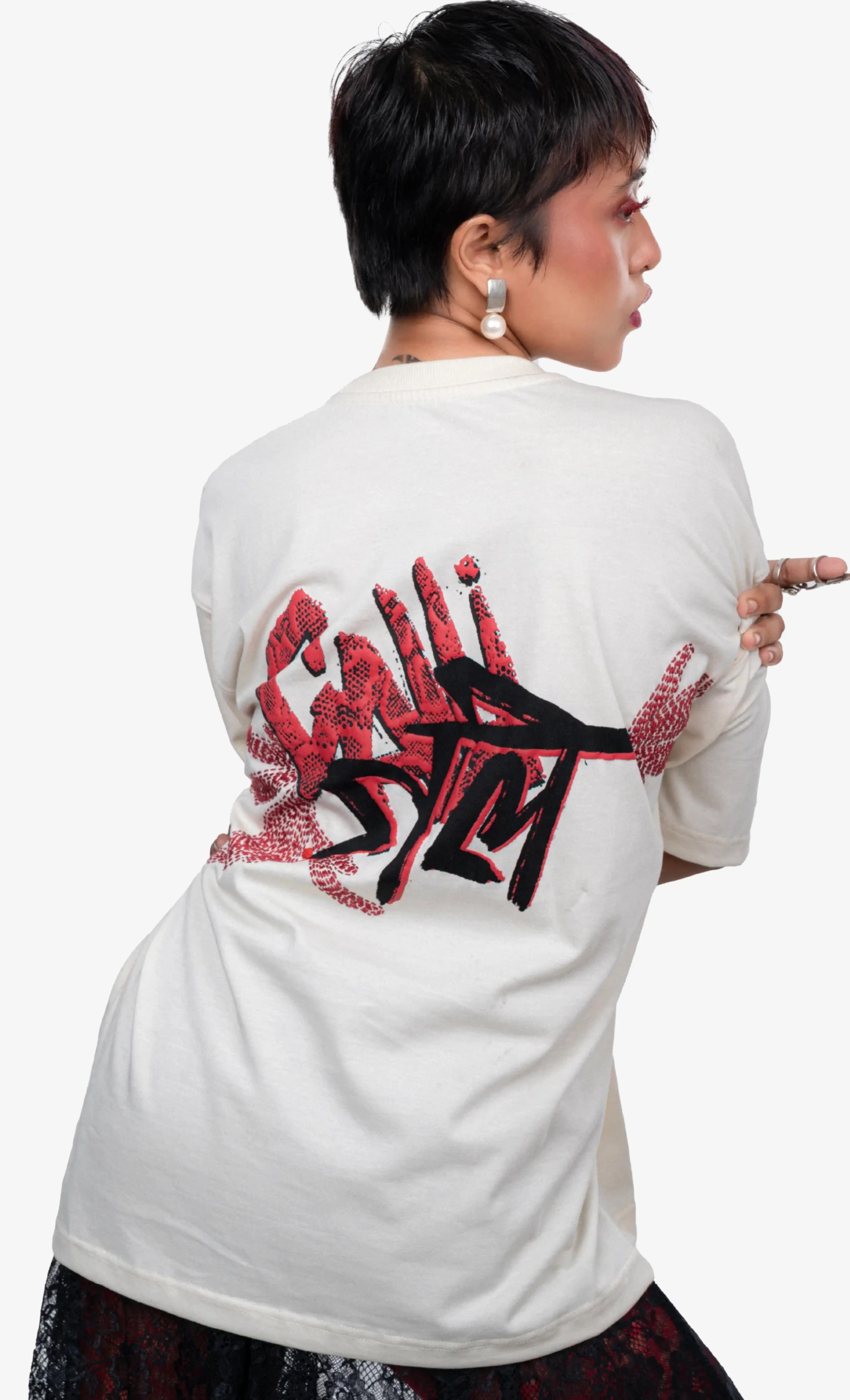 Person wearing a white t-shirt with red and black graphics on the back, standing against a white background.