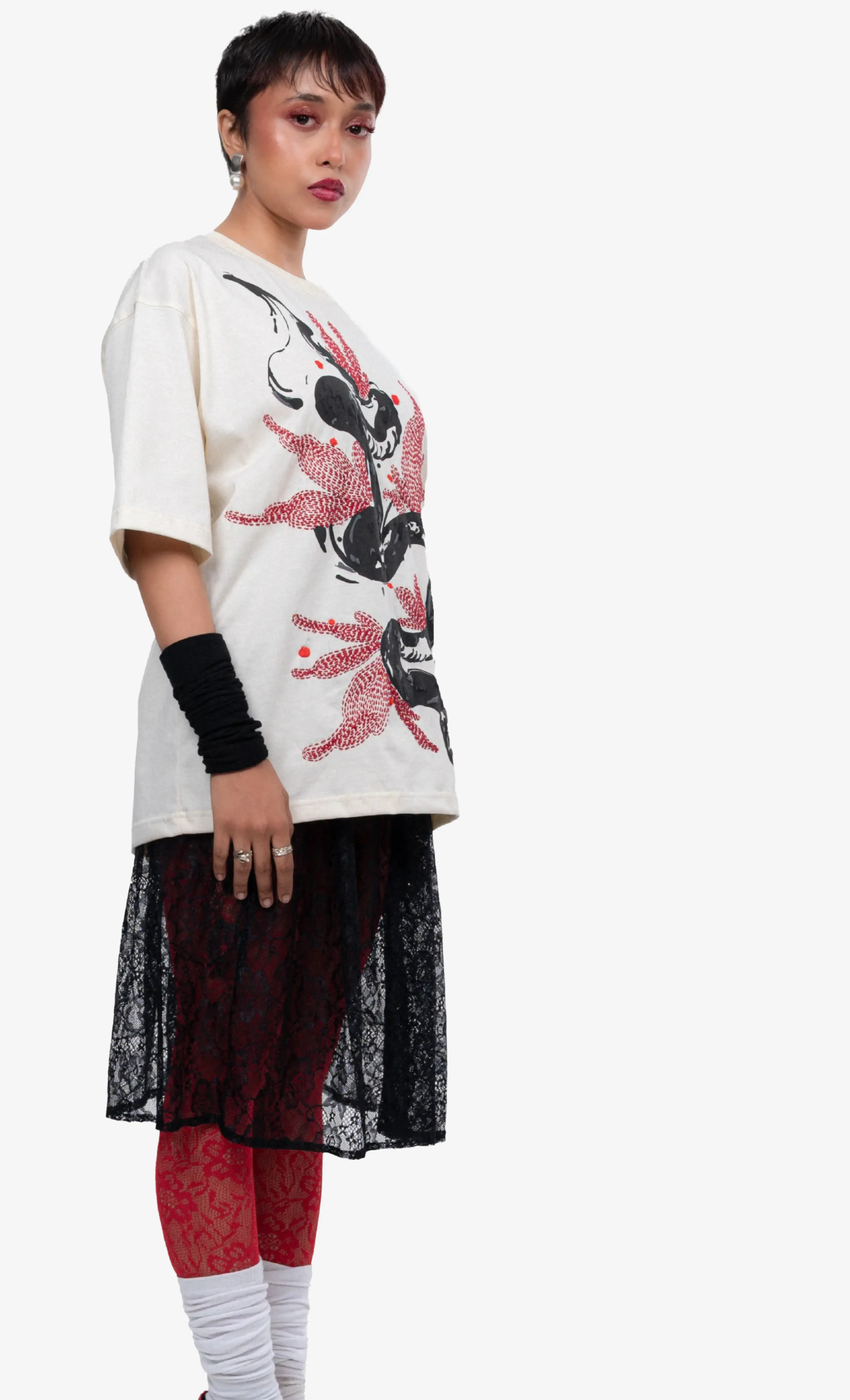 Person wearing a white t-shirt with a graphic design and black pants on a white background