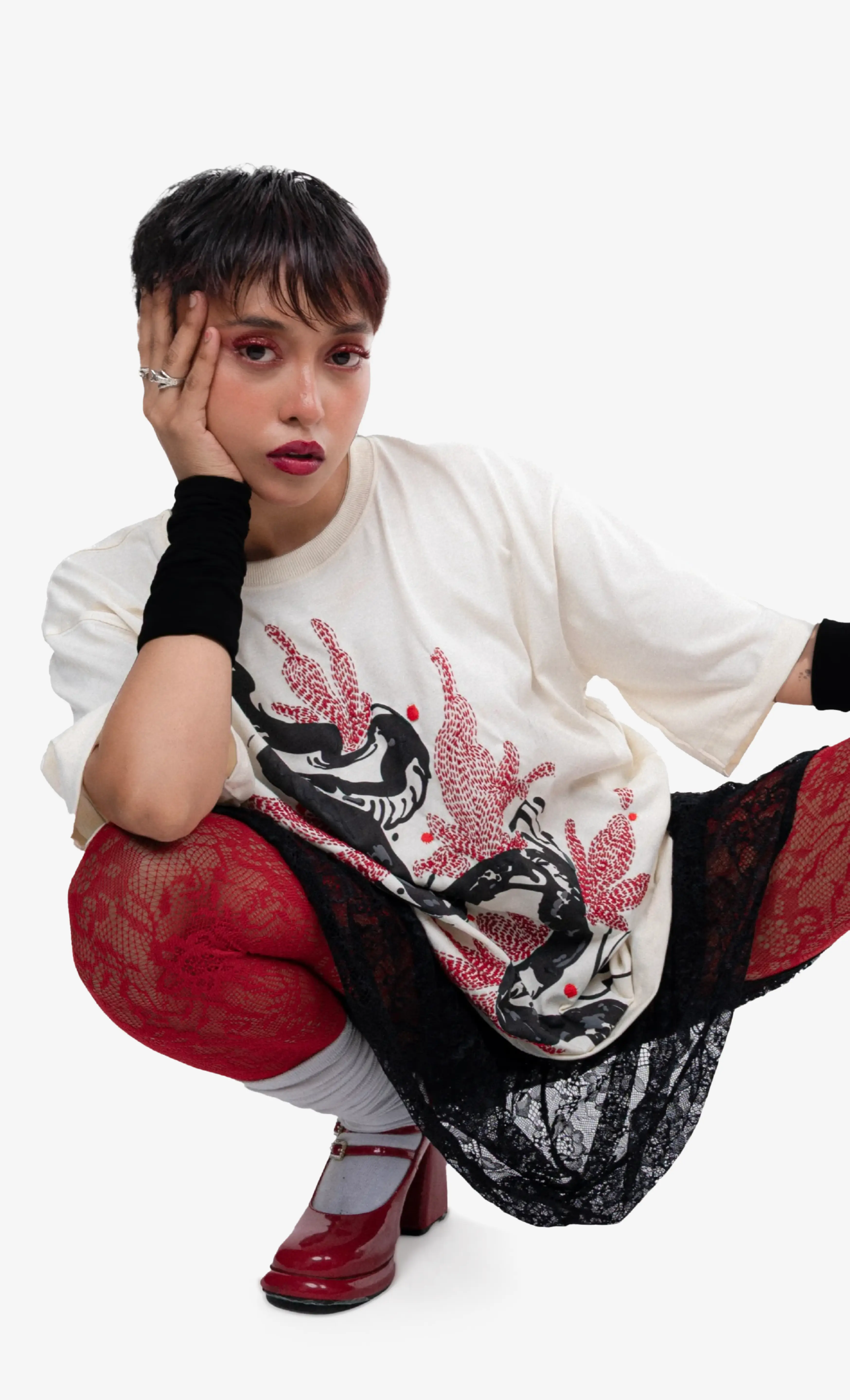 Person wearing a white shirt with a dragon design, red pants, and black shoes on a white background