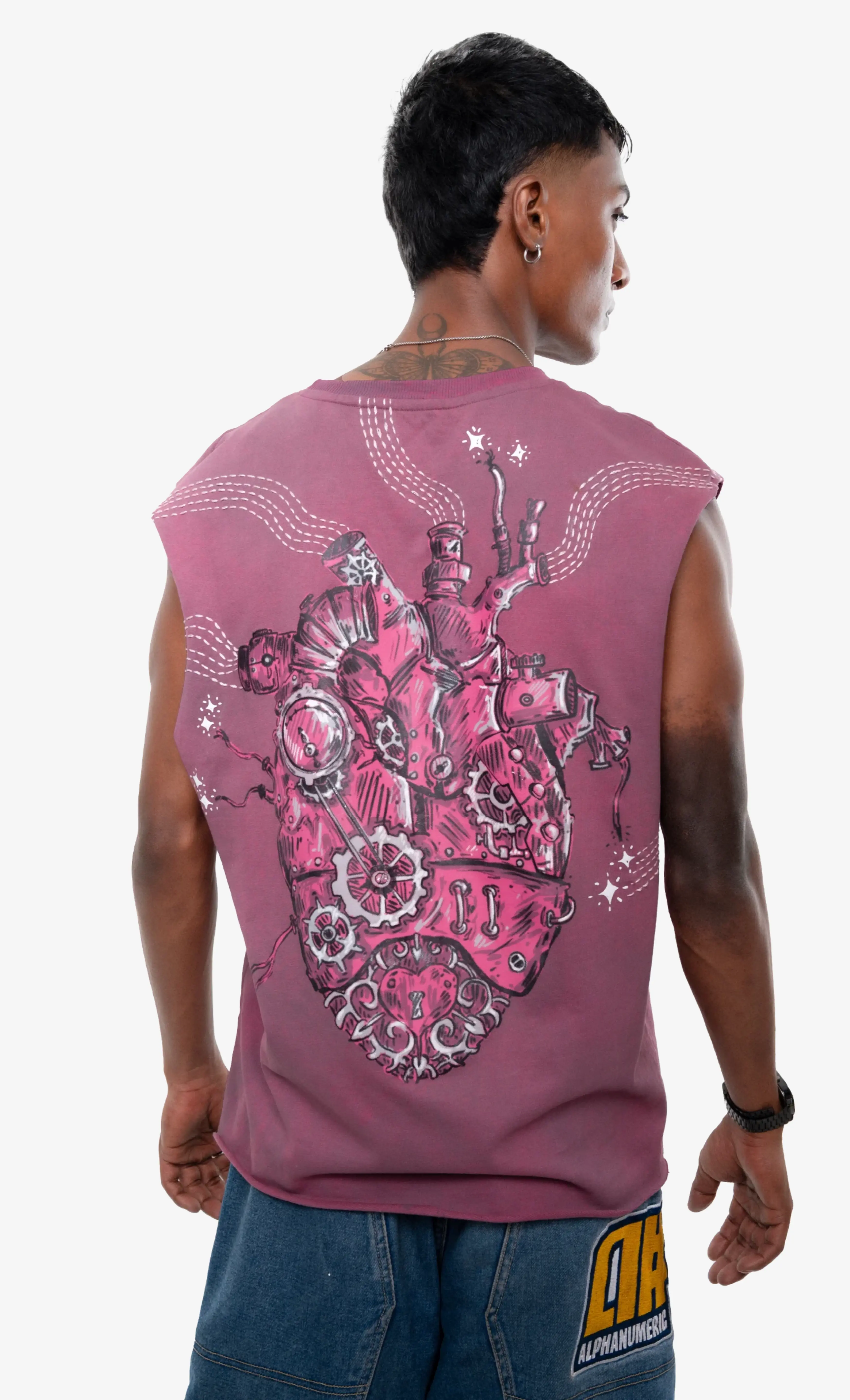 Person wearing a pink sleeveless shirt with a detailed design on the back, standing against a white background.