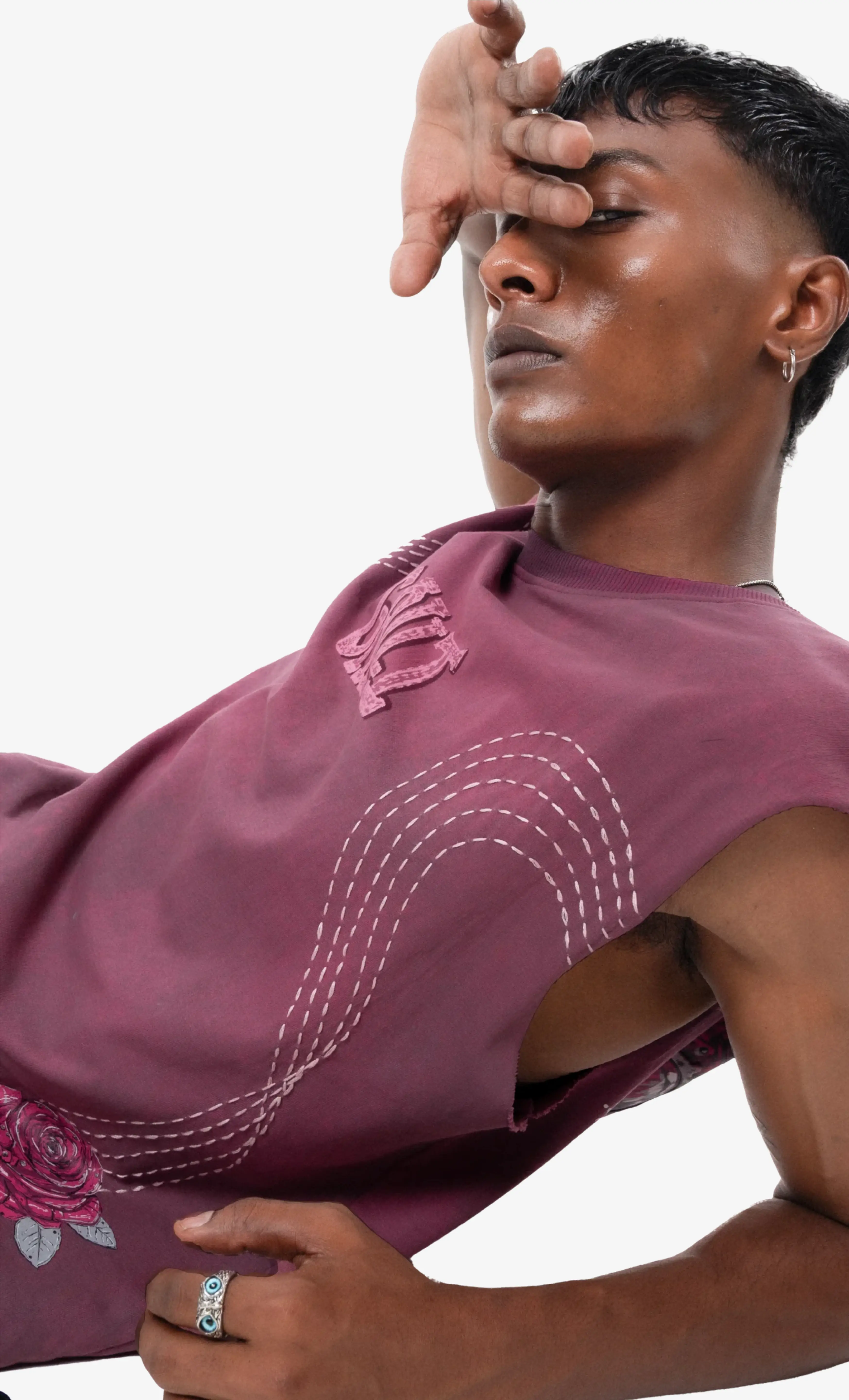 Person wearing a maroon top with floral and embroidery details on a white background